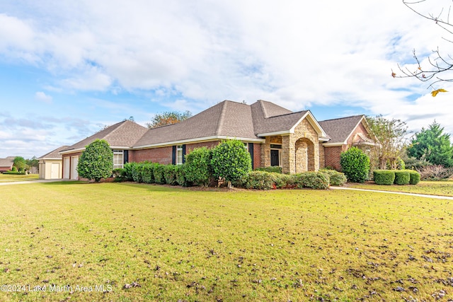 view of front of property featuring a front yard and a garage