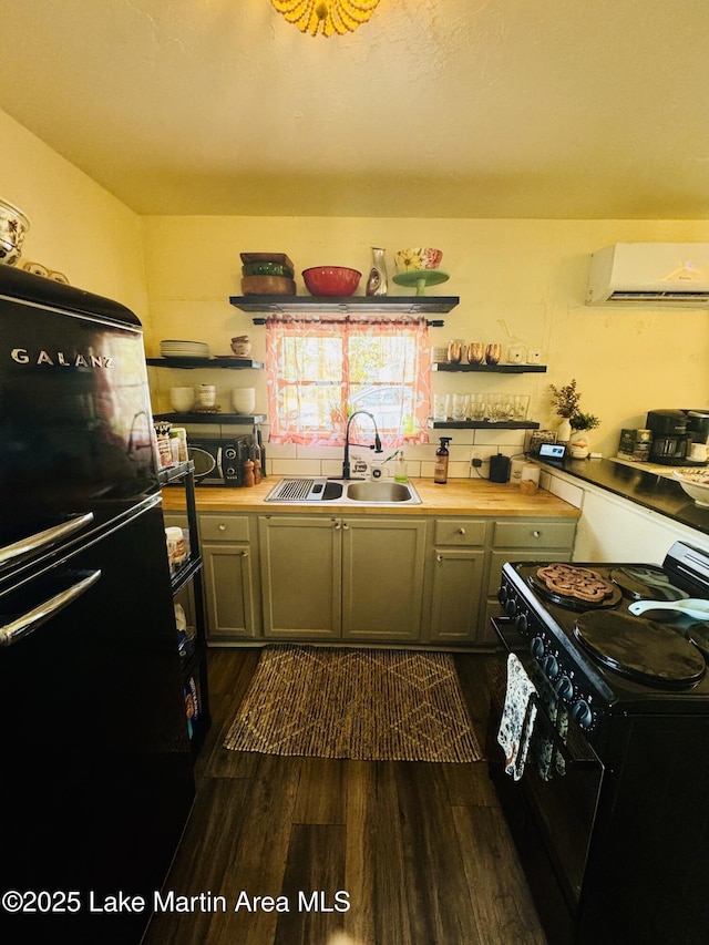 kitchen featuring butcher block counters, sink, dark hardwood / wood-style flooring, a wall unit AC, and black appliances