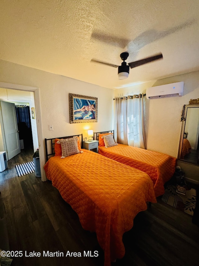 bedroom featuring ceiling fan, an AC wall unit, dark wood-type flooring, and a textured ceiling