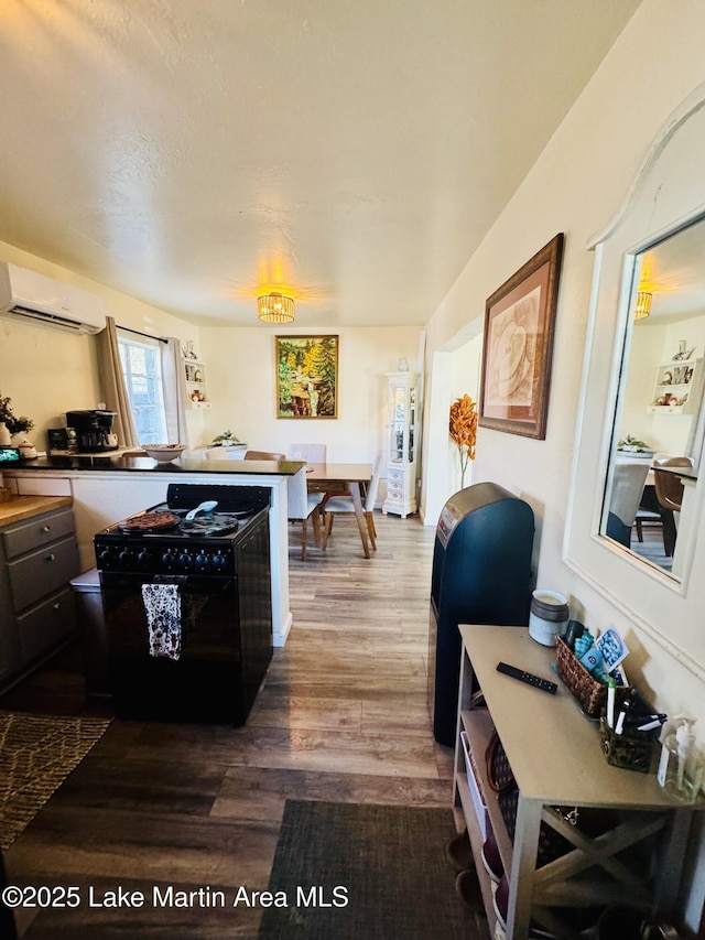 kitchen featuring wood-type flooring and an AC wall unit