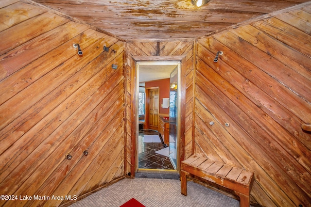 hallway with wooden walls and vaulted ceiling