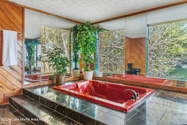 bathroom with tiled bath, wooden walls, and a textured ceiling