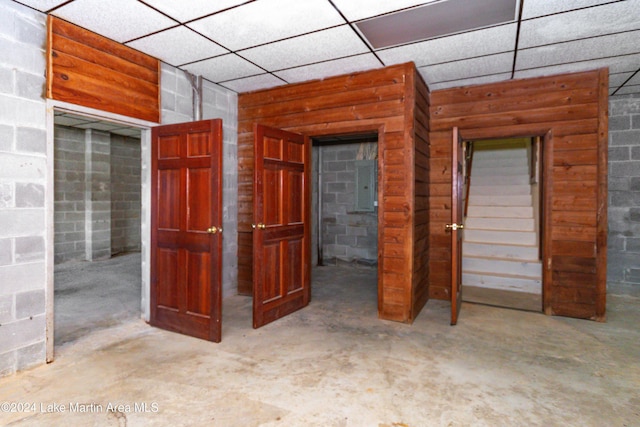 interior space featuring concrete floors, electric panel, and a paneled ceiling