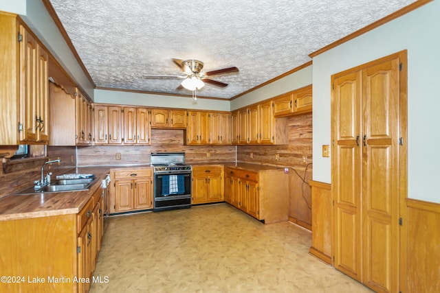 kitchen with black gas range, ceiling fan, sink, crown molding, and a textured ceiling