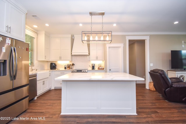 120 Rocky Creek Dr, Alexander City, AL 35010 - kitchen featuring appliances with stainless steel finishes, custom range hood, white cabinets, open floor plan, and decorative backsplash