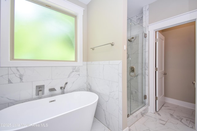 120 Rocky Creek Dr, Alexander City, AL 35010 - bathroom with marble look tiles, a freestanding bath, a stall shower, and tile walls
