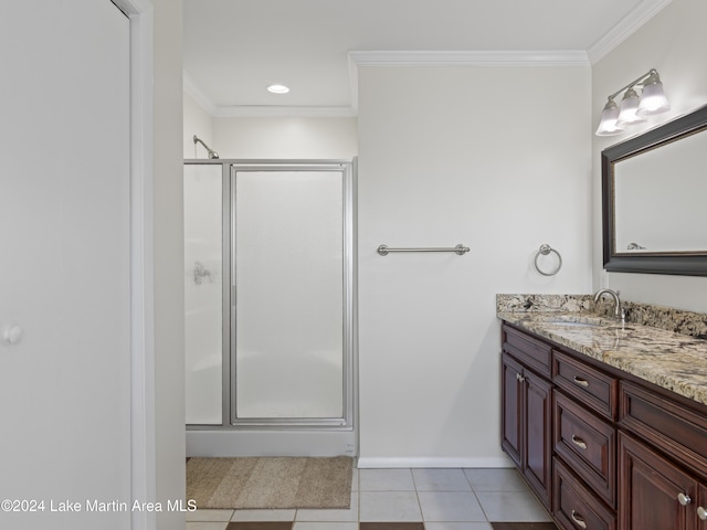 bathroom featuring vanity, tile patterned floors, a shower with door, and ornamental molding