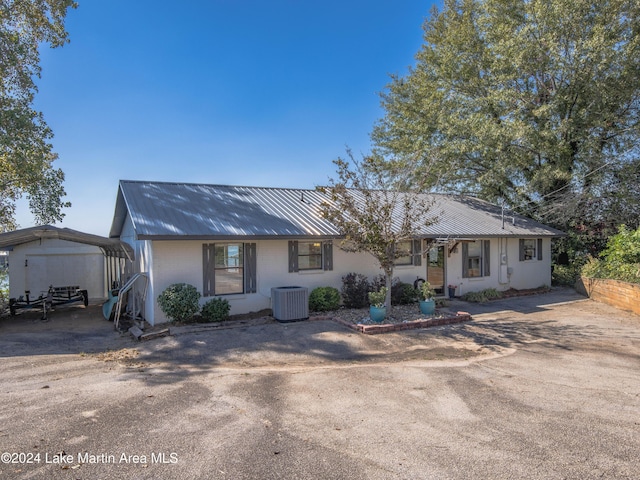 ranch-style home with central AC and a carport