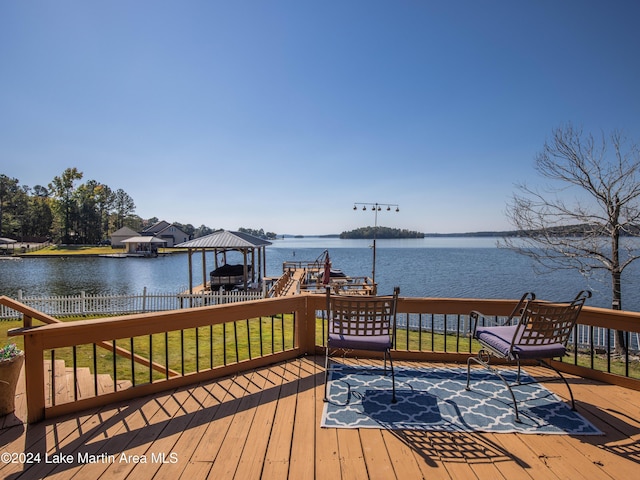 wooden terrace with a water view, a yard, and a gazebo