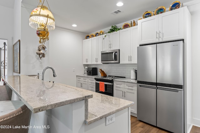 kitchen featuring white cabinets, stainless steel appliances, a center island with sink, and dark wood-type flooring