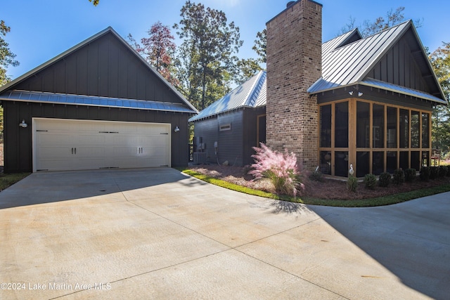 view of side of property featuring a sunroom and a garage