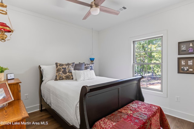 bedroom featuring ceiling fan, dark hardwood / wood-style flooring, and crown molding