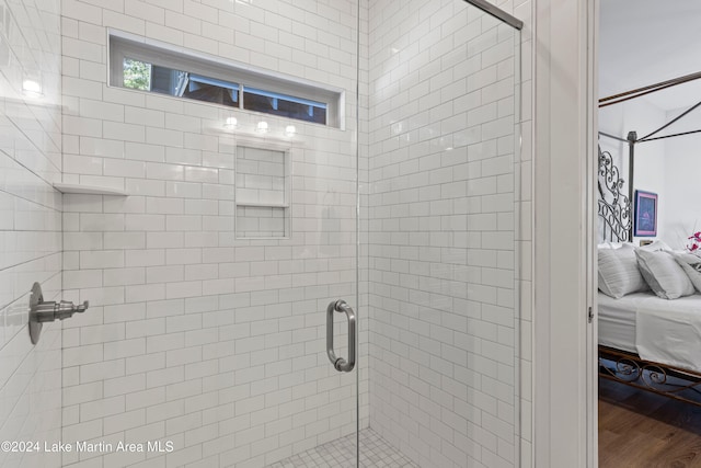 bathroom with an enclosed shower and hardwood / wood-style flooring