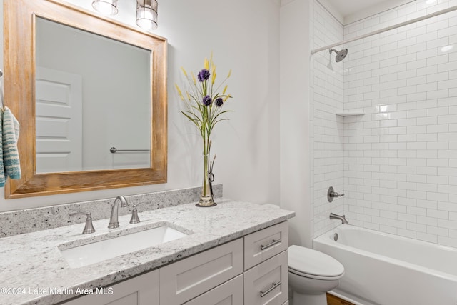 full bathroom with toilet, vanity, and tiled shower / bath