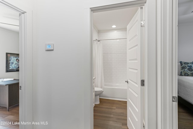 bathroom featuring hardwood / wood-style floors, shower / tub combo, and toilet