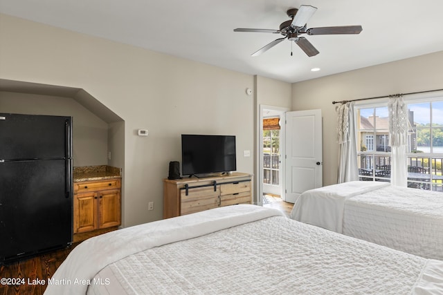 bedroom with black fridge, ceiling fan, dark hardwood / wood-style flooring, and access to outside