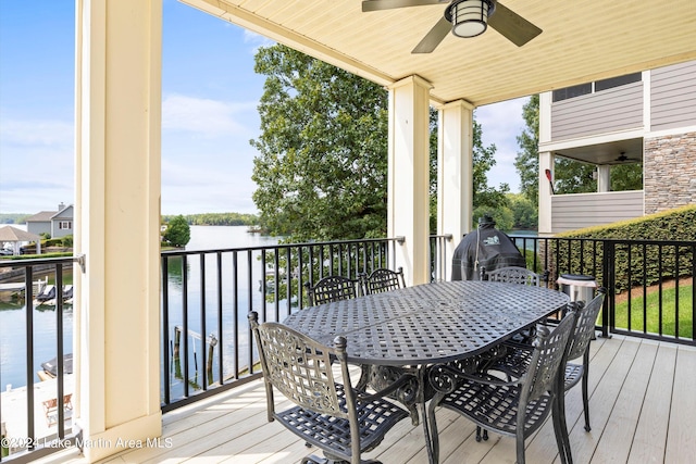 deck featuring ceiling fan and a water view