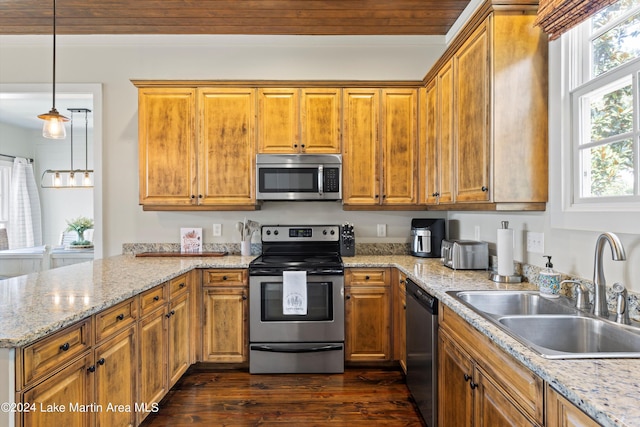 kitchen with decorative light fixtures, stainless steel appliances, sink, dark hardwood / wood-style floors, and light stone counters