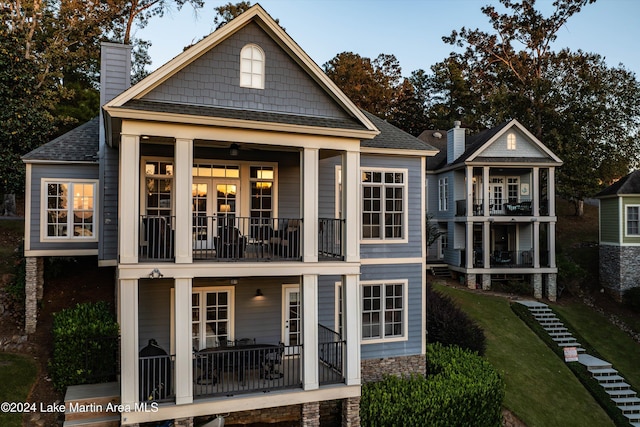 back of property with a balcony and french doors