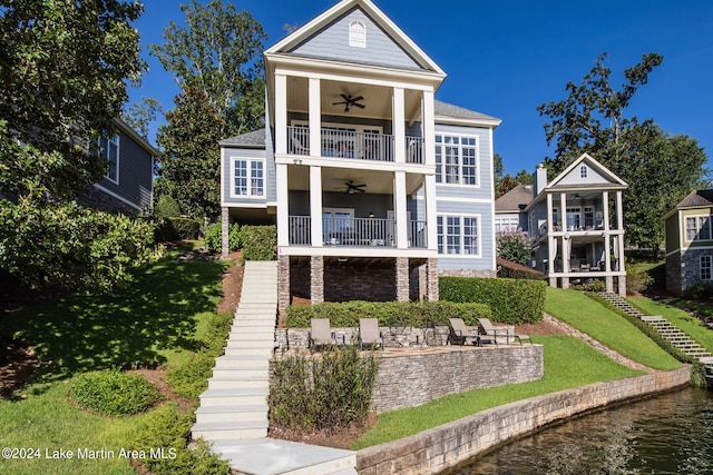 back of house with ceiling fan, a patio area, a yard, and a balcony