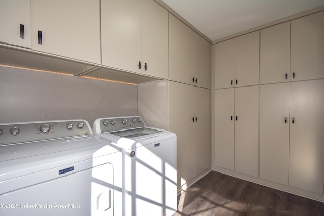 laundry area featuring dark wood finished floors, cabinet space, and independent washer and dryer