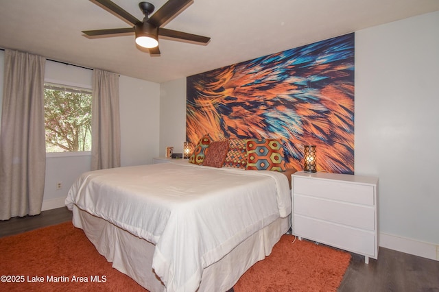 bedroom with a ceiling fan, baseboards, and wood finished floors