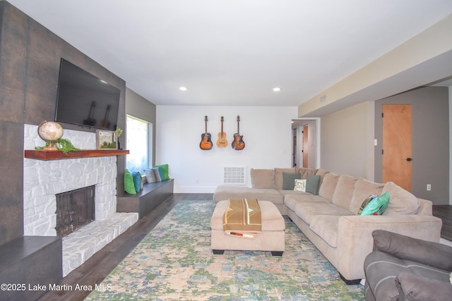 living room with visible vents, wood finished floors, recessed lighting, a fireplace, and baseboards