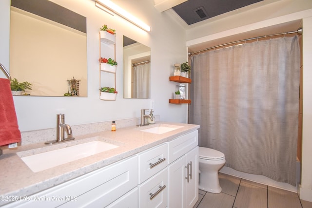 full bathroom with a sink, visible vents, toilet, and double vanity