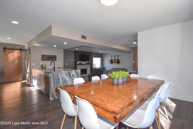 dining area with visible vents, recessed lighting, a barn door, and dark wood-style flooring