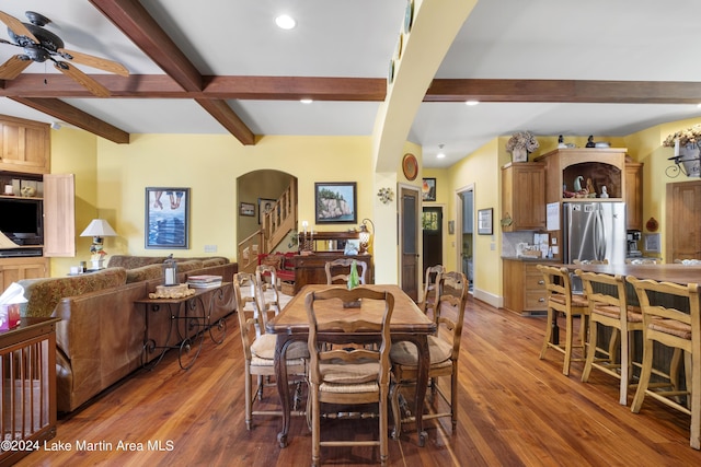 dining space featuring beamed ceiling, wood-type flooring, and ceiling fan