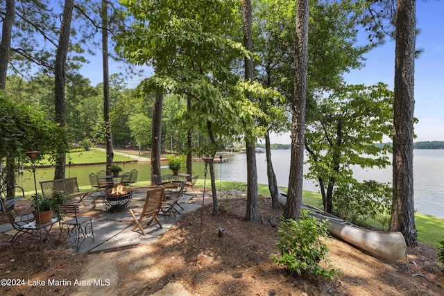 view of yard featuring a water view and an outdoor fire pit