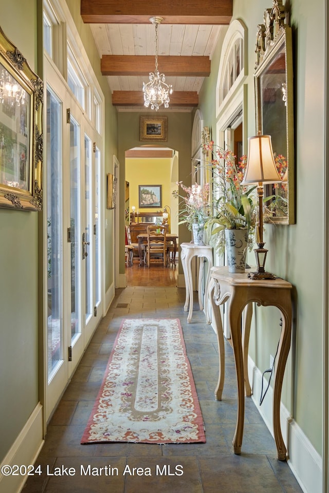 hall featuring a chandelier, beam ceiling, french doors, and wood ceiling