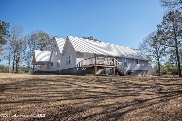 rear view of property with a yard, stairs, metal roof, and a wooden deck