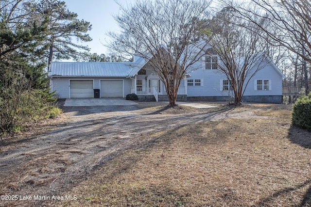 ranch-style home featuring an attached garage, metal roof, and dirt driveway