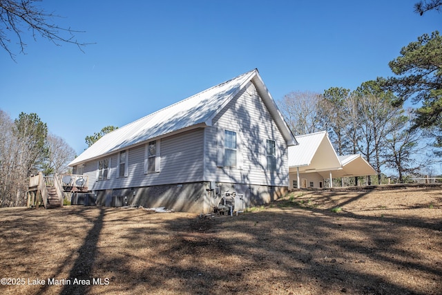 view of side of home featuring metal roof and stairway