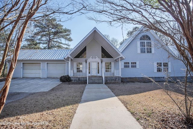 view of front facade with metal roof, concrete driveway, and an attached garage