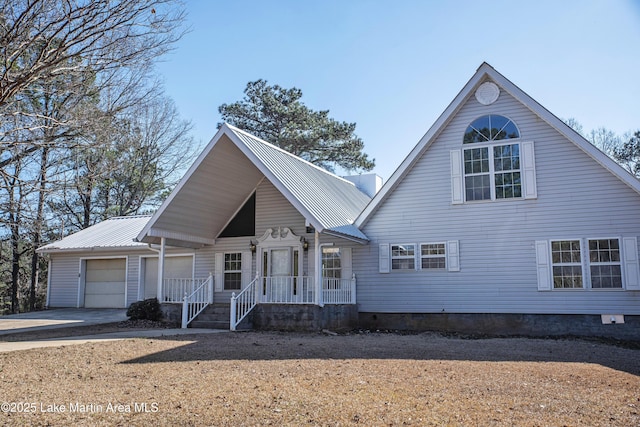 view of front of house featuring a garage, driveway, and metal roof