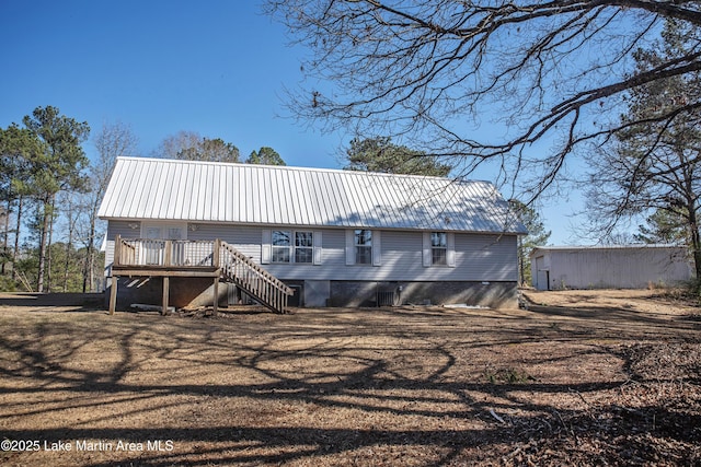 back of house featuring metal roof, a wooden deck, and stairs