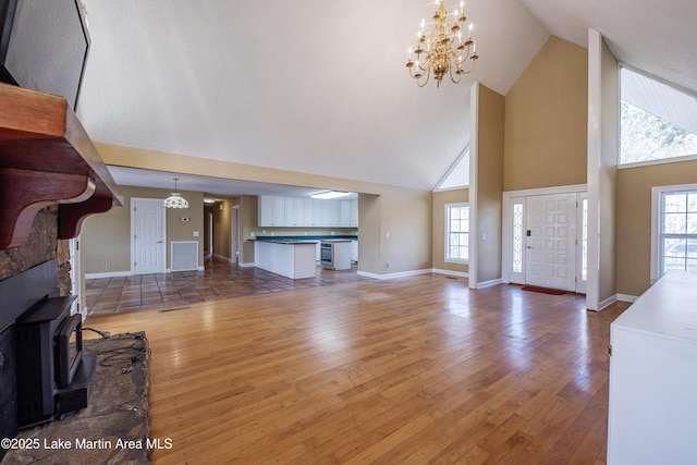 living room with wood-type flooring, visible vents, and a wealth of natural light