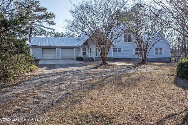 1676 Scott Rd, Alexander City, AL 35010 - view of front of house with dirt driveway, a garage, metal roof, and a porch