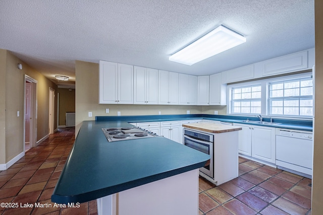 kitchen with gas cooktop, stainless steel oven, white cabinets, dishwasher, and dark countertops