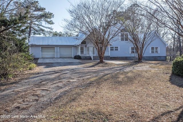 ranch-style home featuring an attached garage, dirt driveway, and metal roof