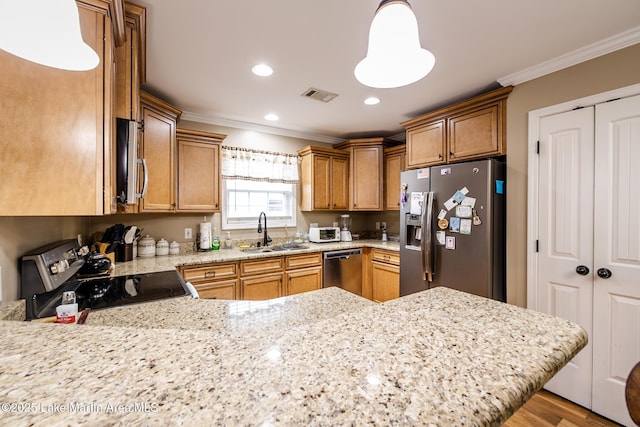 kitchen with light stone countertops, appliances with stainless steel finishes, a sink, a peninsula, and crown molding