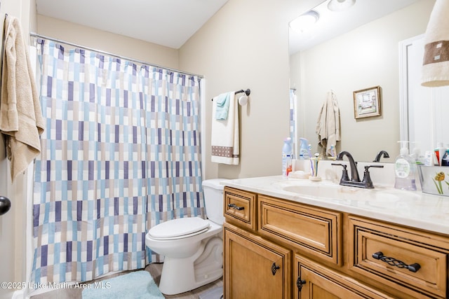full bathroom with curtained shower, toilet, and vanity