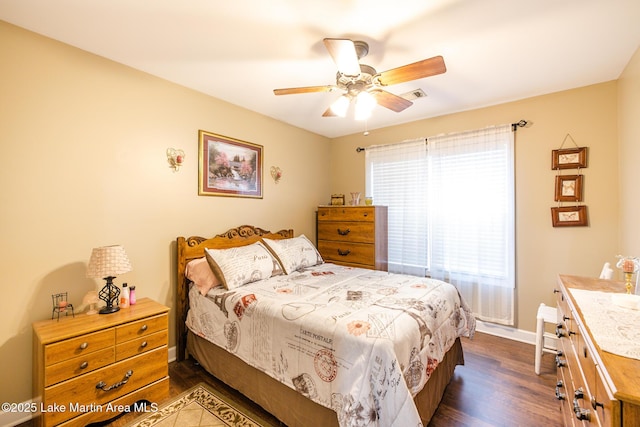 bedroom with dark wood finished floors, visible vents, a ceiling fan, and baseboards