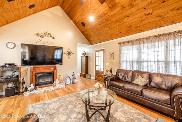 living room featuring wood ceiling, a glass covered fireplace, wood finished floors, and high vaulted ceiling