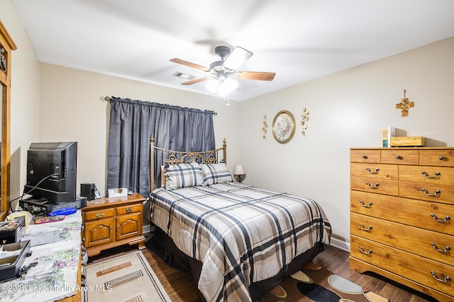 bedroom with visible vents, ceiling fan, and dark wood-style floors