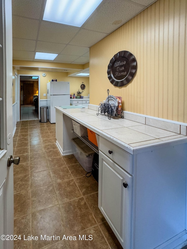 clothes washing area featuring dark tile patterned flooring and wooden walls