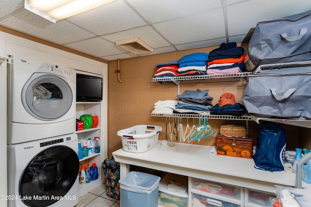 washroom featuring tile patterned flooring and stacked washer / dryer