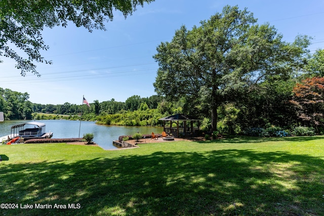 view of yard with a gazebo, a boat dock, and a water view